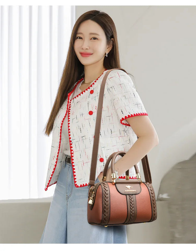 Woman holding a brown handbag indoors with a neutral background