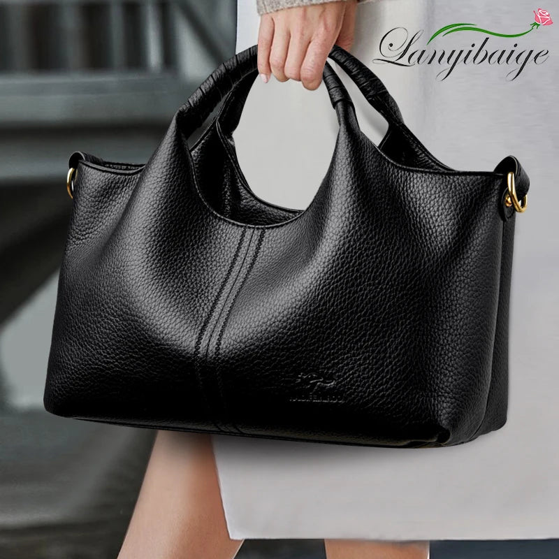 Black leather handbag held by a person with 'Lanyibaihe' branding.