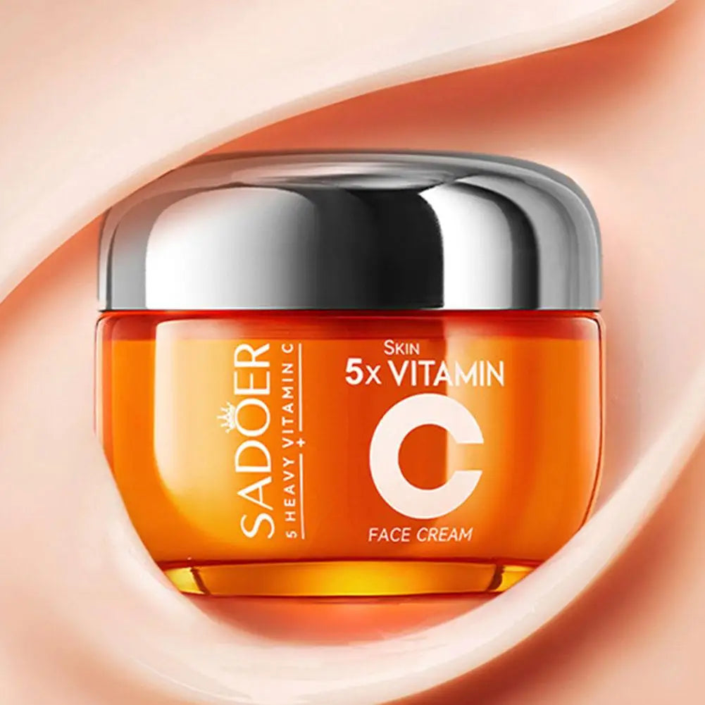 Orange face cream jar with silver lid on a peach background