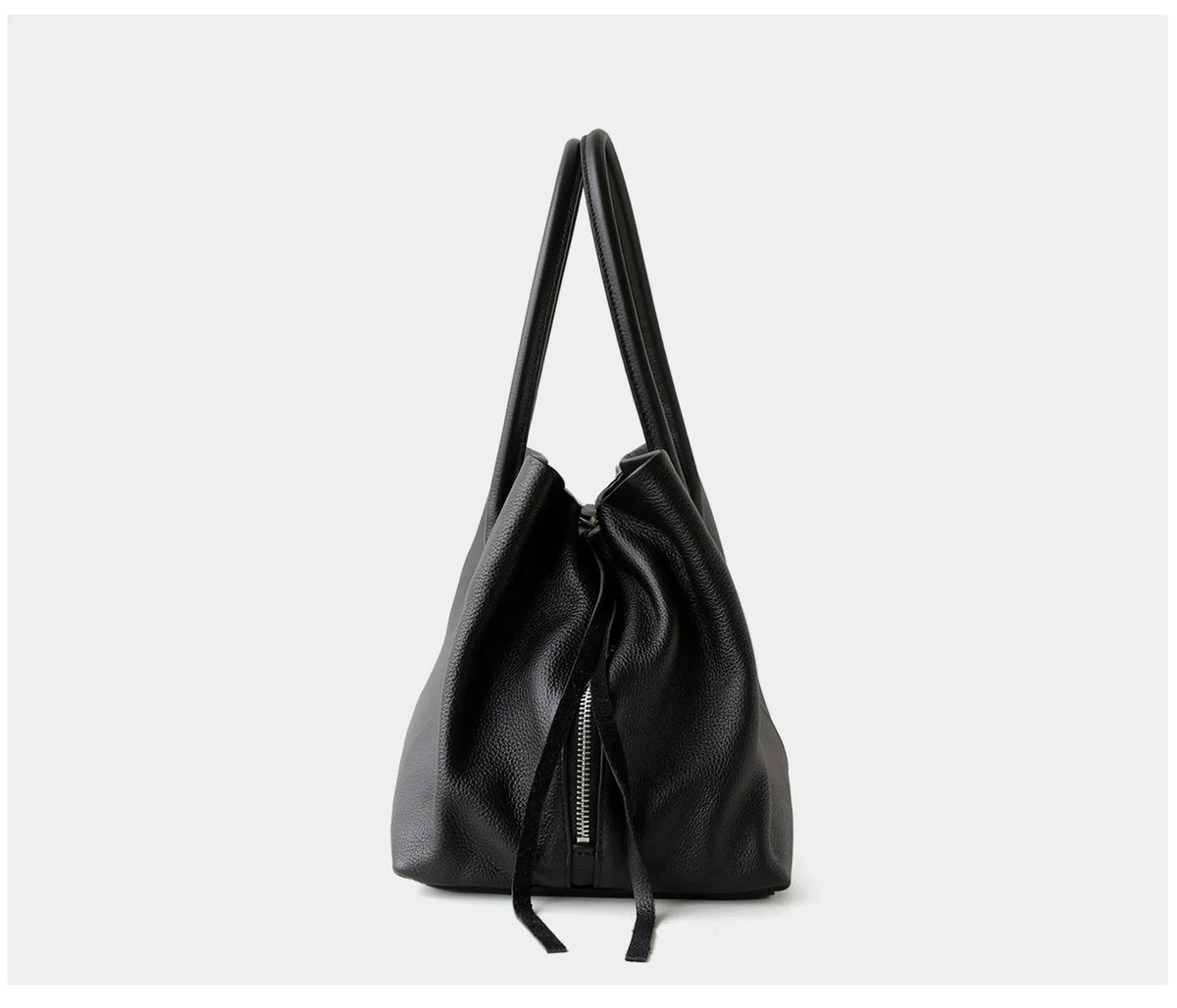 Black handbag with a drawstring on a light gray background