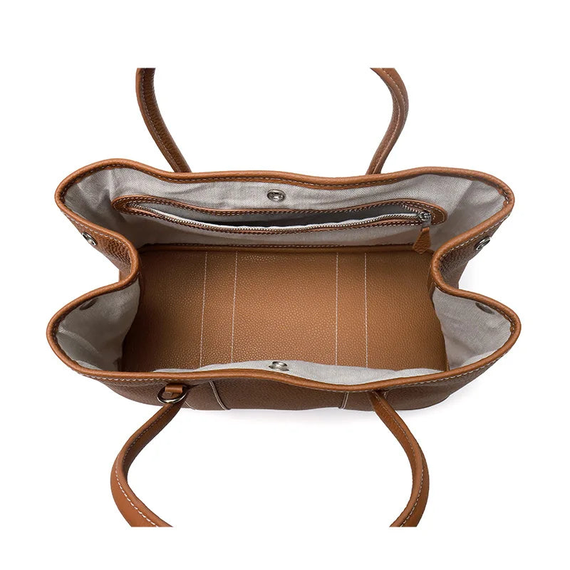 Brown leather handbag with visible stitching on a white background