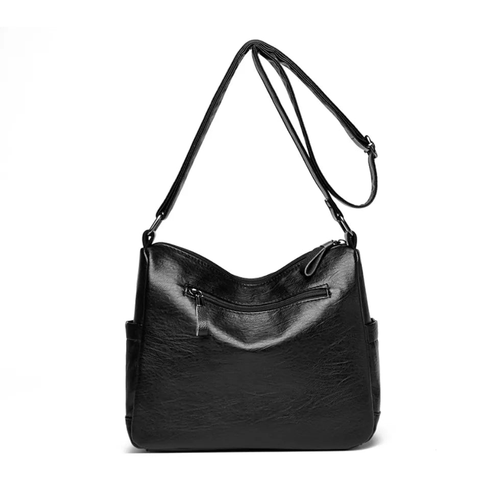 Black leather handbag with a shoulder strap on a white background
