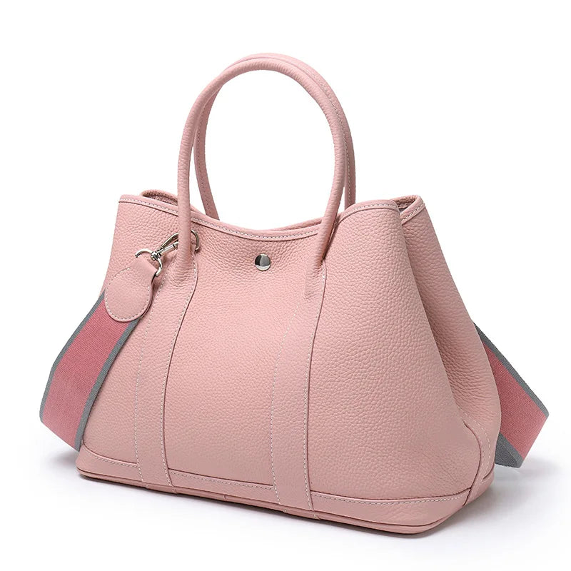 Pink handbag with a strap on a white background