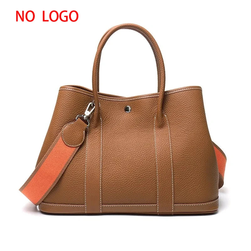 Brown leather handbag with an orange strap on a white background