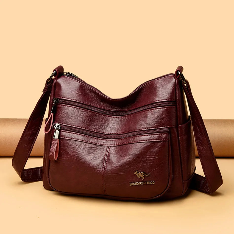 Brown leather handbag with a visible brand logo on a beige background