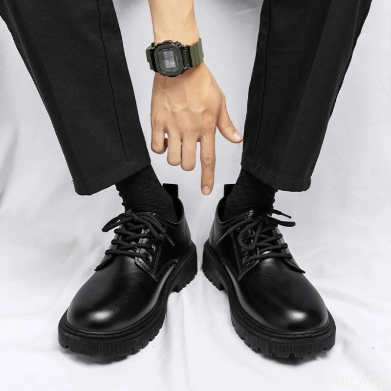 Black leather shoes worn with black pants on a white background
