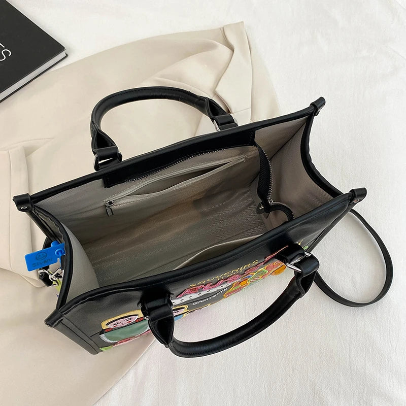 Black handbag with a floral patterned interior on a white surface