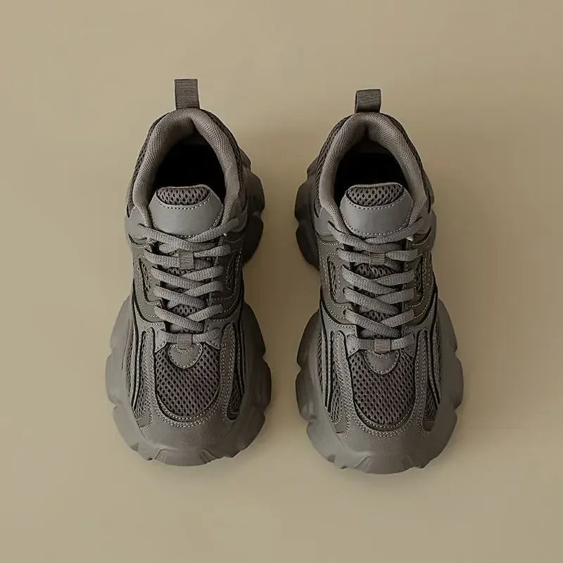Pair of gray sneakers on a beige background