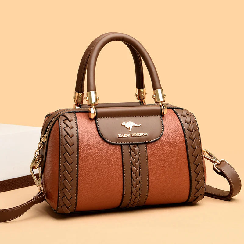 Brown handbag with gold accents on a beige background