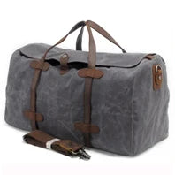Gray duffel bag with brown leather straps on a white background