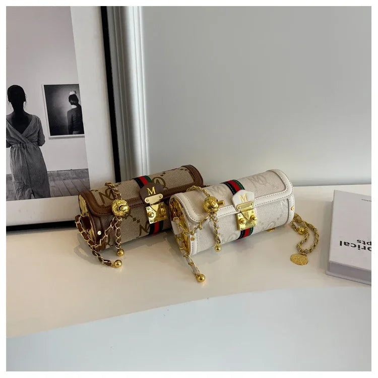 Two decorative boxes with gold chains and red and black accents on a light surface.