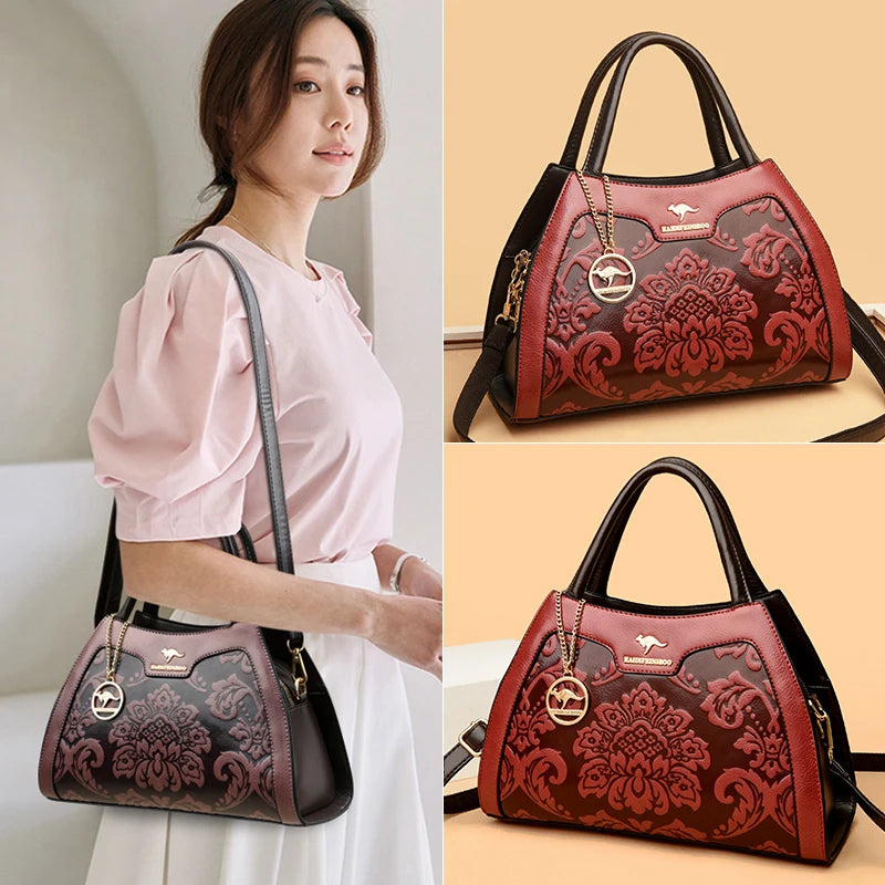 Woman holding a red and black handbag with intricate designs, displayed against a beige background.