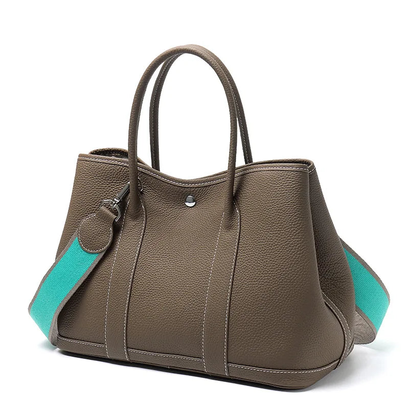 Brown handbag with turquoise accents on a white background