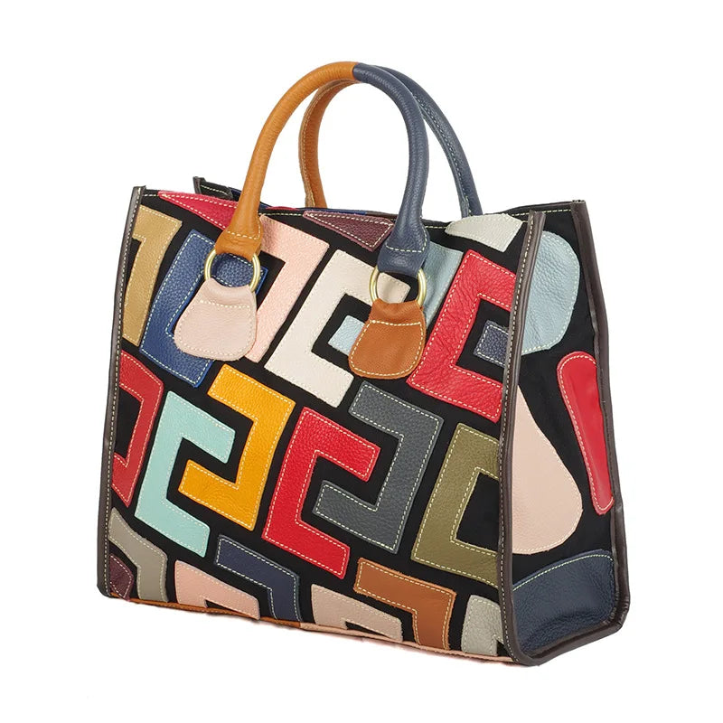 Colorful geometric patterned handbag with brown handles on a white background