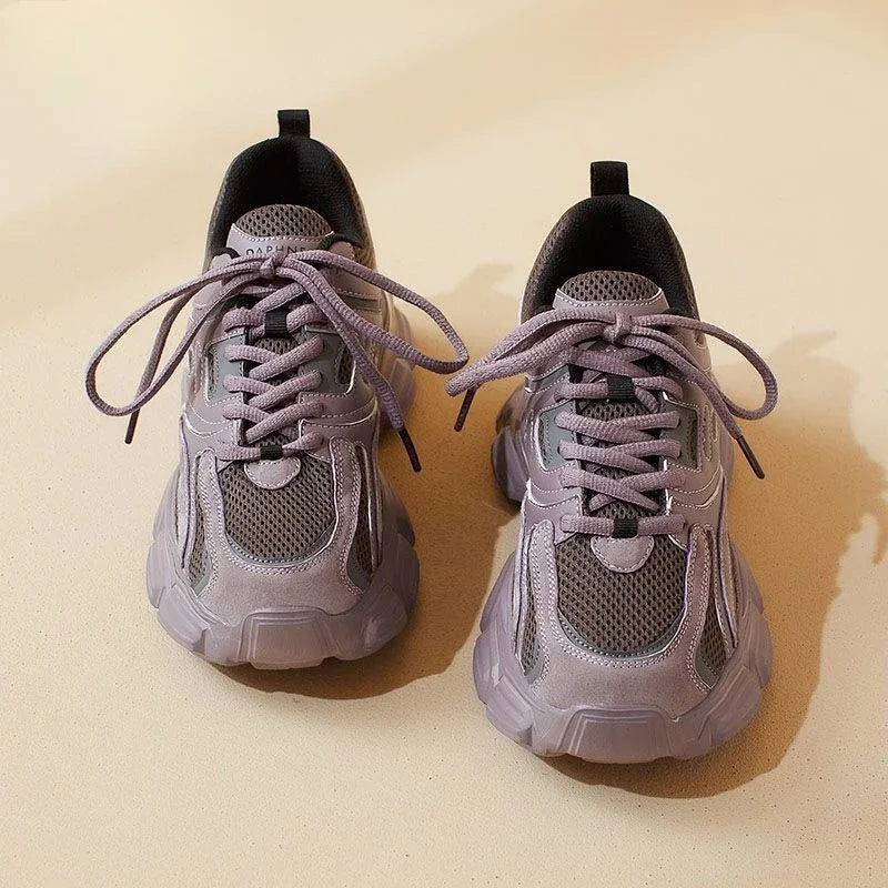 Pair of light purple sneakers on a beige background