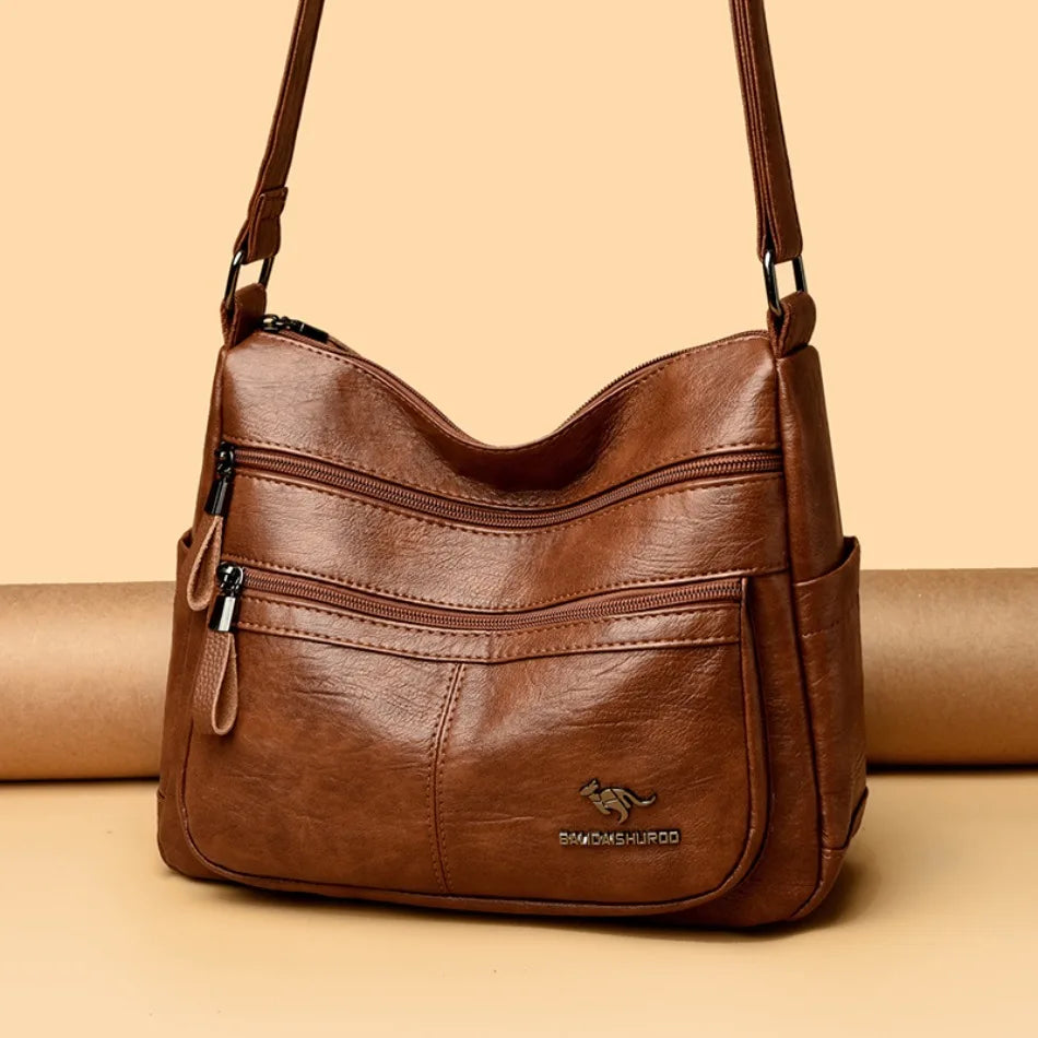 Brown leather handbag with a visible brand logo on a beige background