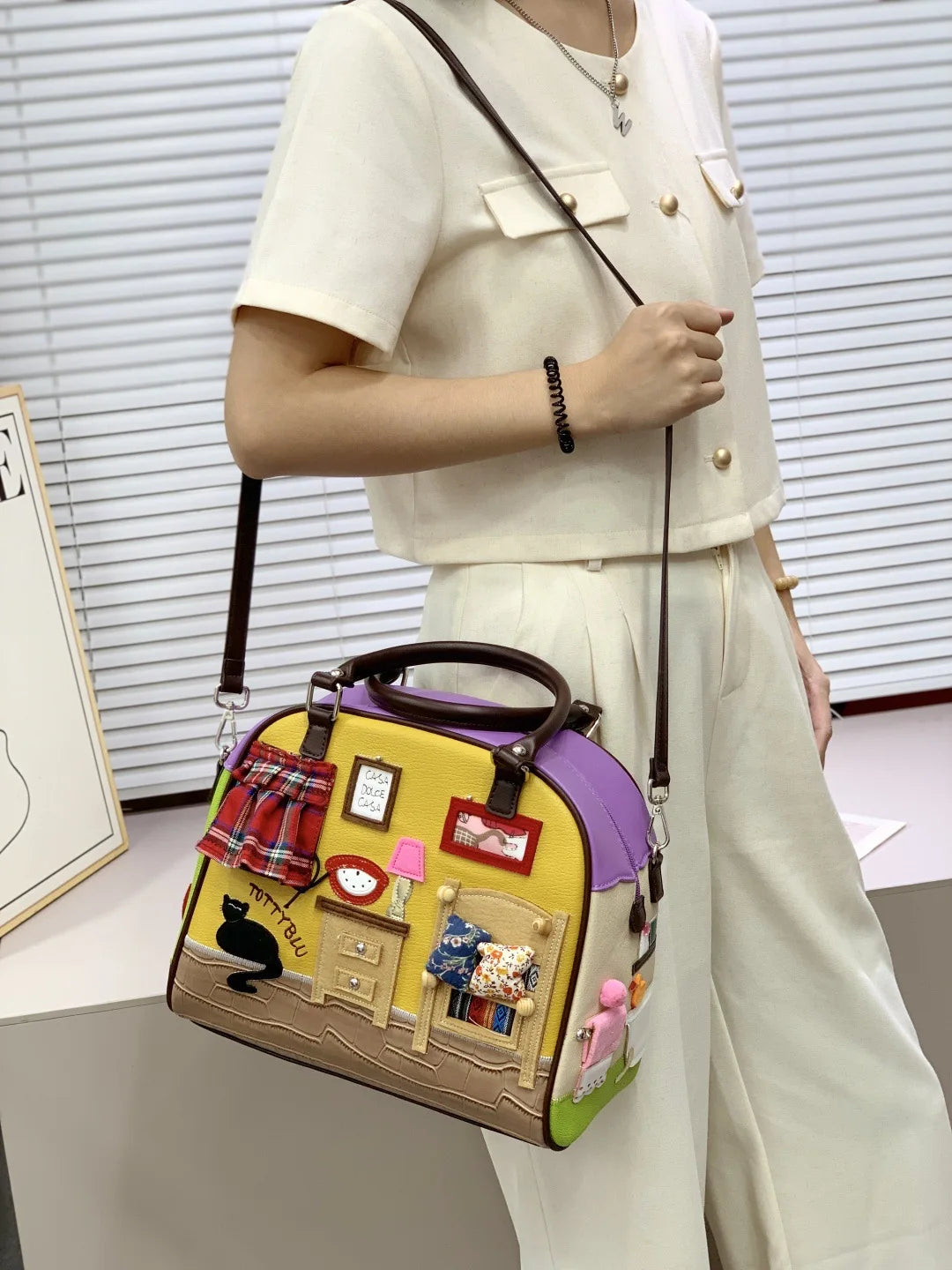 Person holding a colorful handbag with decorative elements