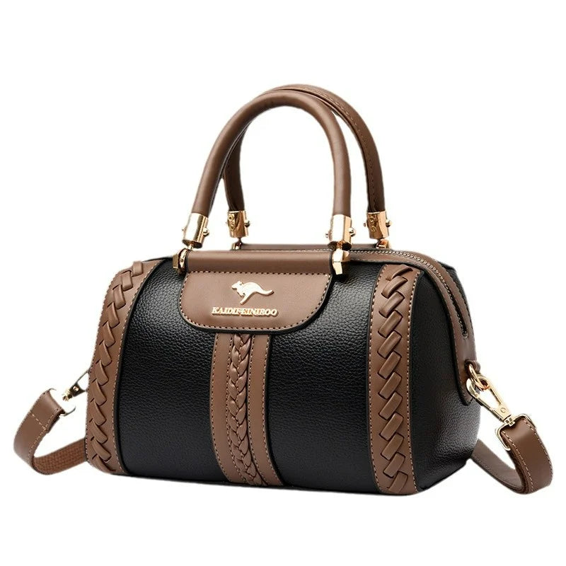 A structured black and brown handbag with pebbled leather texture, braided side panels, dual top handles, and a gold kangaroo logo on the front flap, shown on a plain white background.