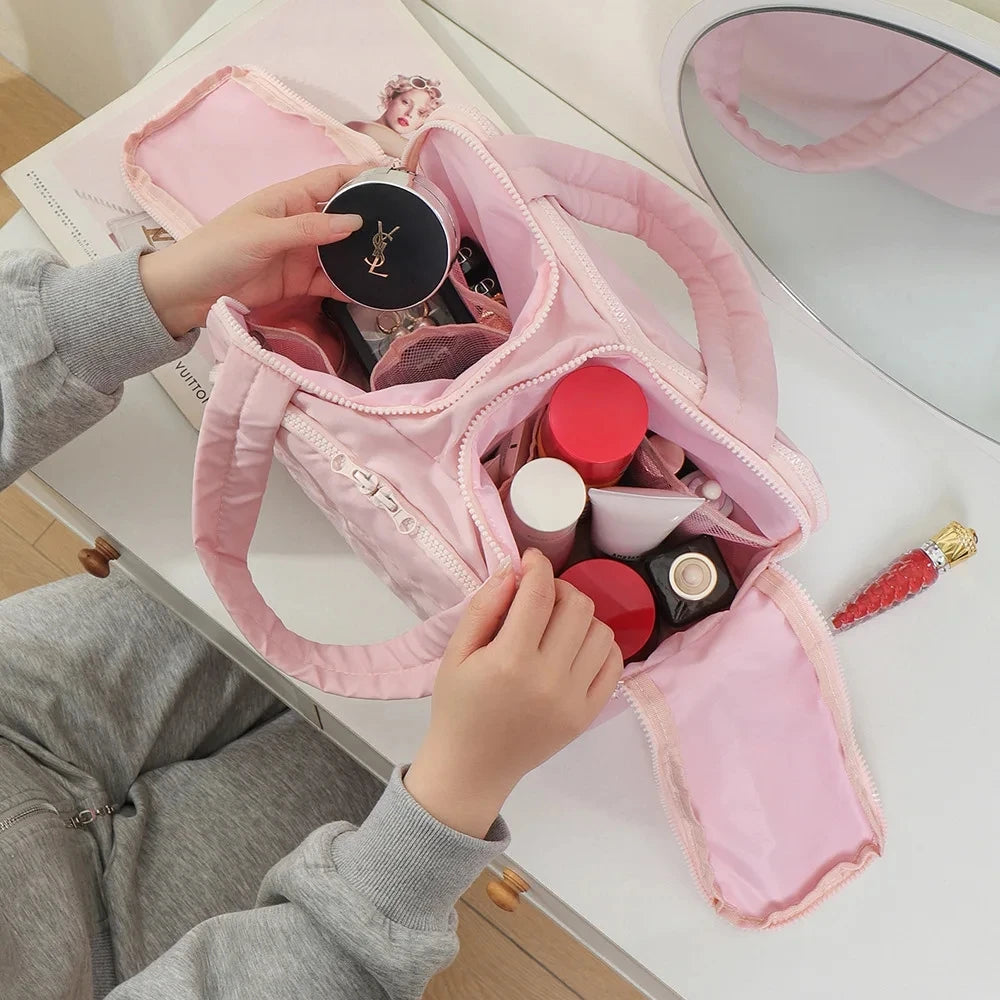 Pink bra filled with makeup items on a white surface
