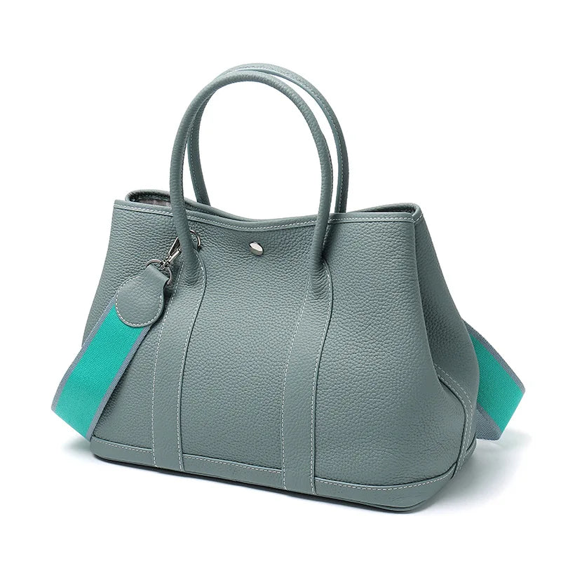 Gray handbag with turquoise accents on a white background