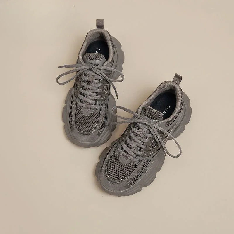 Pair of gray sneakers on a beige background
