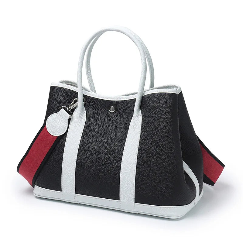 Black, white, and red handbag on a white background