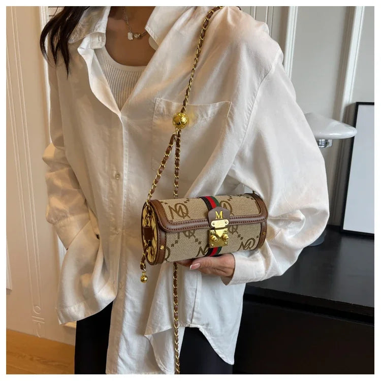 Person holding a patterned handbag with a visible brand logo, wearing a white shirt.