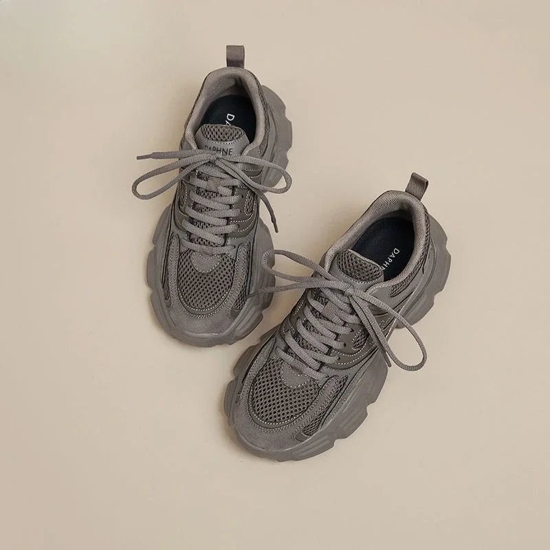 Pair of gray sneakers on a beige background