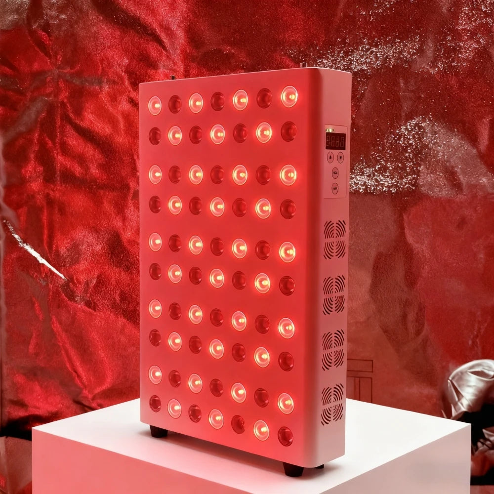 Red light therapy device on a white platform with a red curtain background