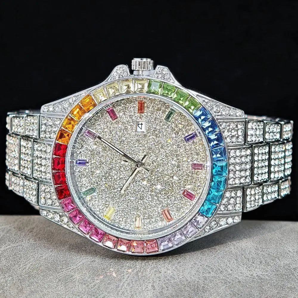 A heavily embellished wristwatch with a silver-toned case and bracelet paved with clear stones, featuring a rainbow-colored bezel and multicolored hour markers on a glittery silver dial, set against a black background.