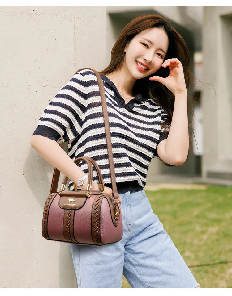 Woman holding a brown handbag and smiling outdoors