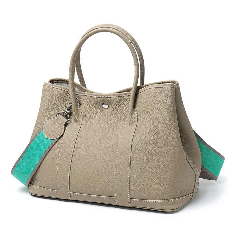 Beige handbag with turquoise accents on a white background