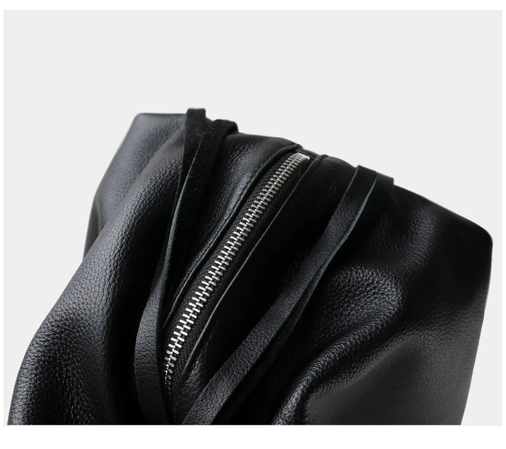 Black leather bag with a zipper on a light gray background
