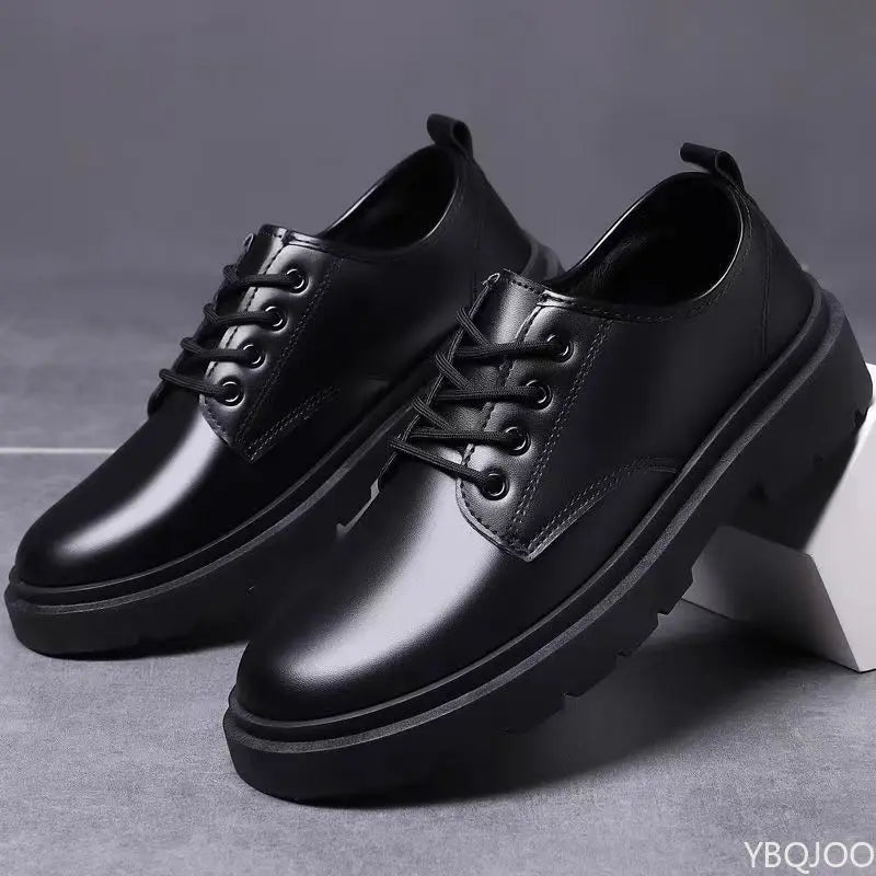 Pair of black leather shoes on a gray background