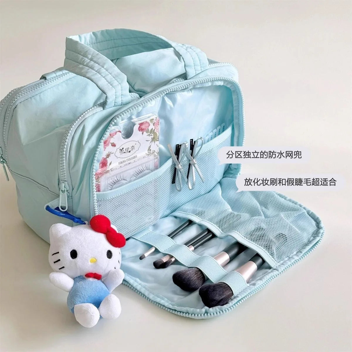 Light blue makeup bag with compartments, brushes, and a Hello Kitty toy on a light background
