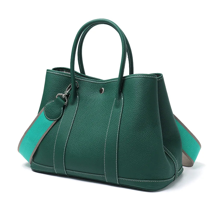 Green handbag with a matching pouch on a white background