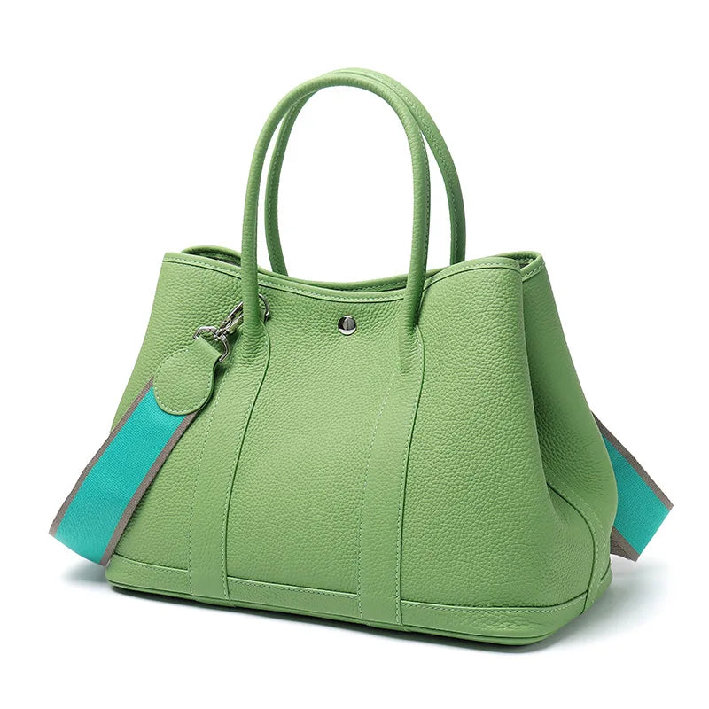 Green handbag with turquoise accents on a white background