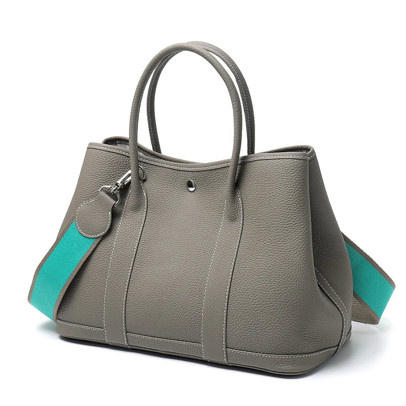 Gray handbag with turquoise accents on a white background