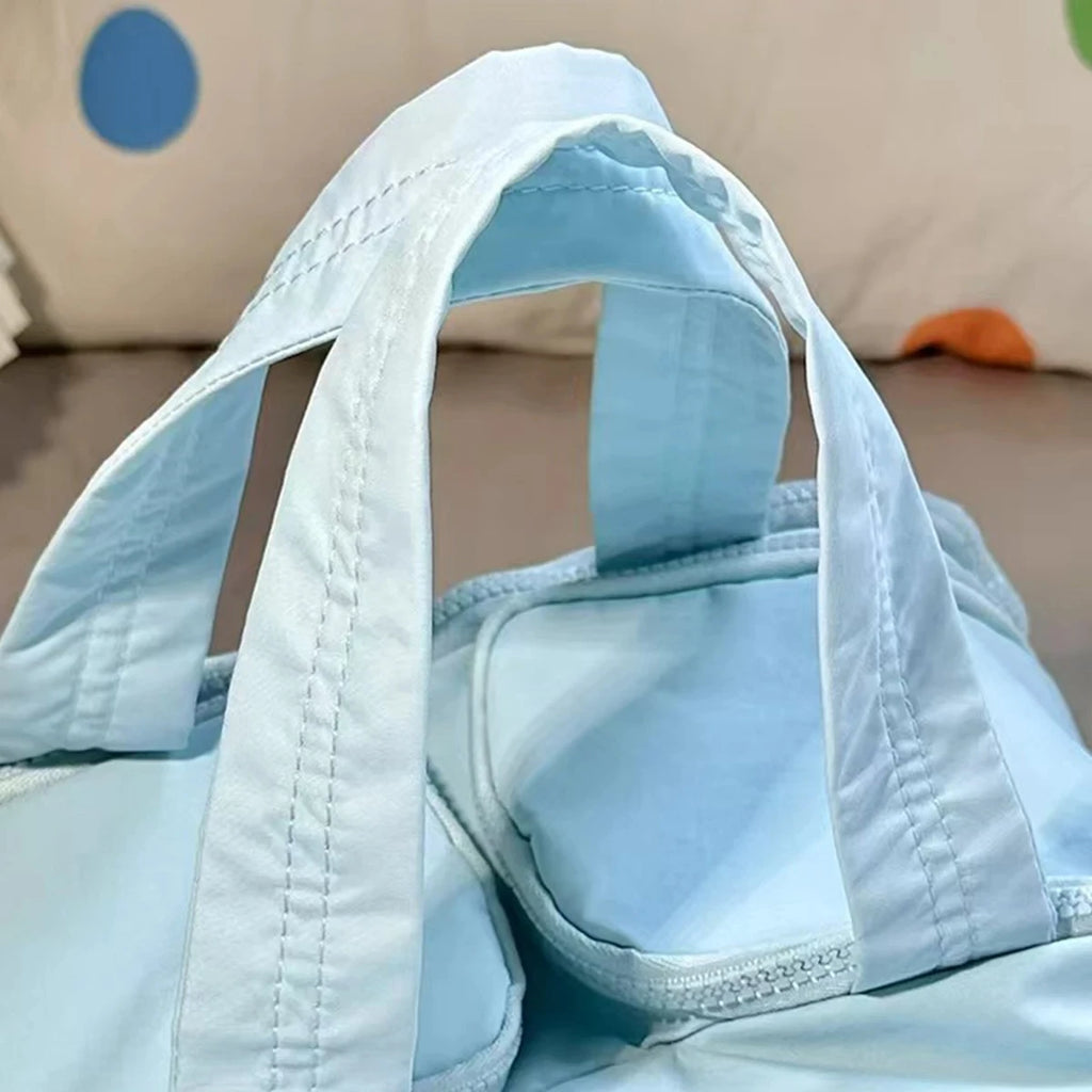 Light blue bag with handles on a neutral background