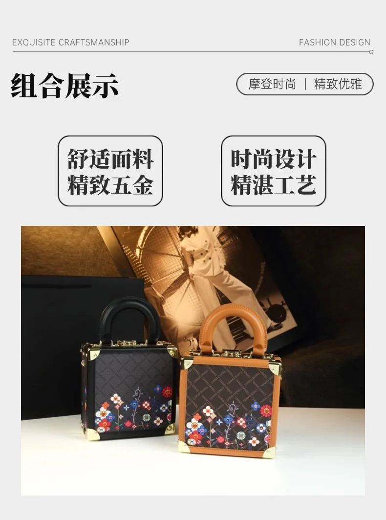 Two small structured handbags displayed side by side on a tabletop, with a magazine and dark background behind them. The left bag is black with a floral patchwork pattern and black handle; the right bag is brown with a matching monogram-style pattern and floral patchwork detail, plus a brown handle.