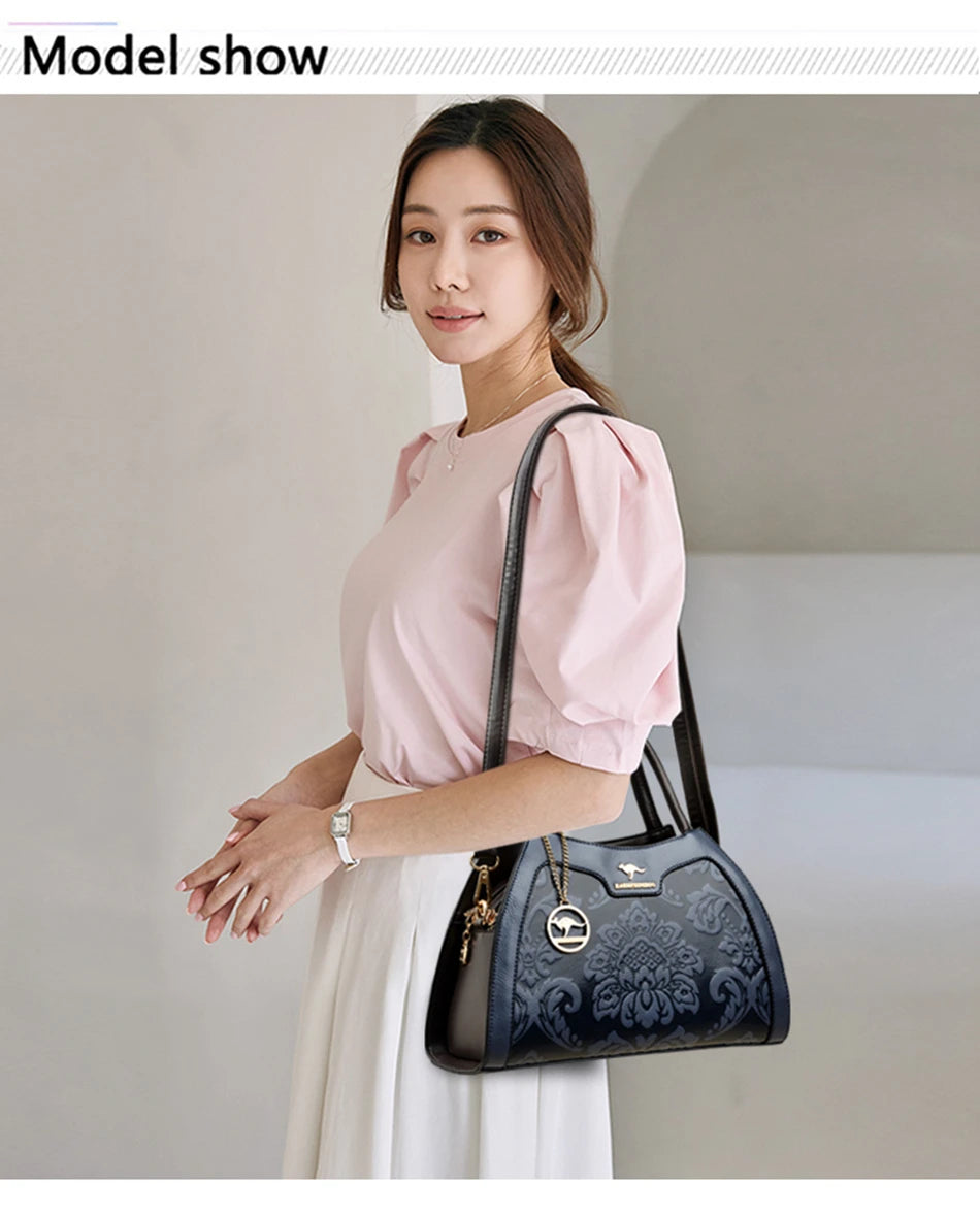 Woman holding a black handbag with intricate design against a plain background