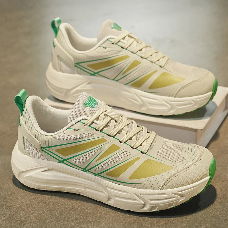 A pair of chunky athletic sneakers in off-white and light green, displayed on a neutral gray surface with one shoe resting on a small white box.