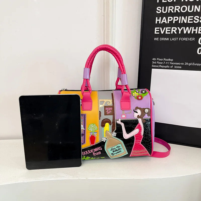Colorful handbag with artistic design next to a tablet on a white surface.