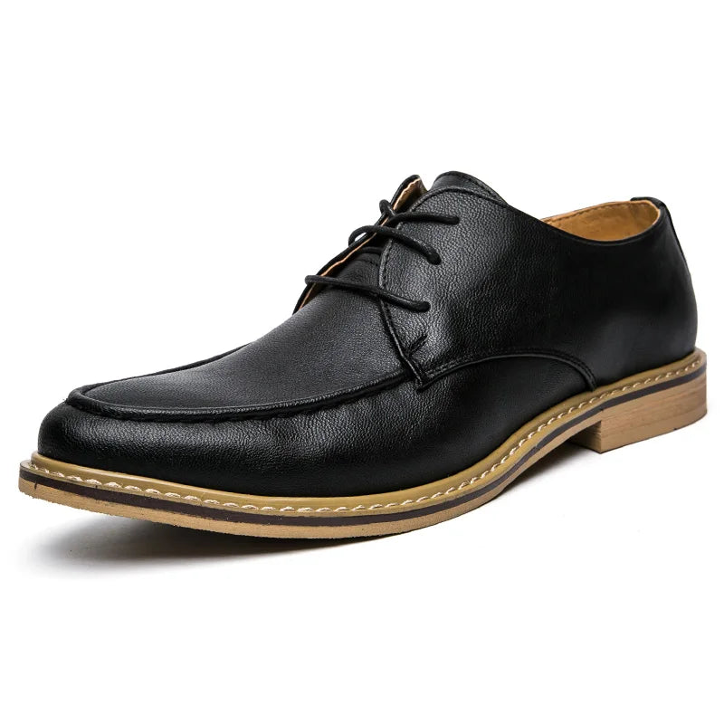 Black leather dress shoe with a brown sole on a white background