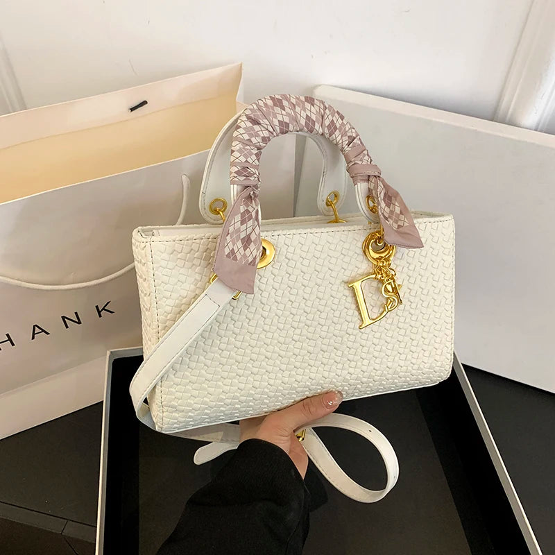 White handbag with gold accents held by a hand, with a 'Dior' logo visible.