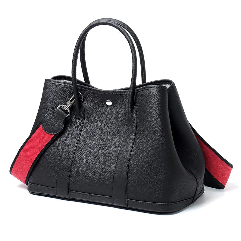 Black handbag with red accents on a white background
