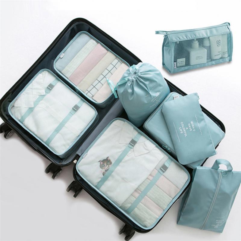 Set of travel packing cubes and bags in light blue on a white background