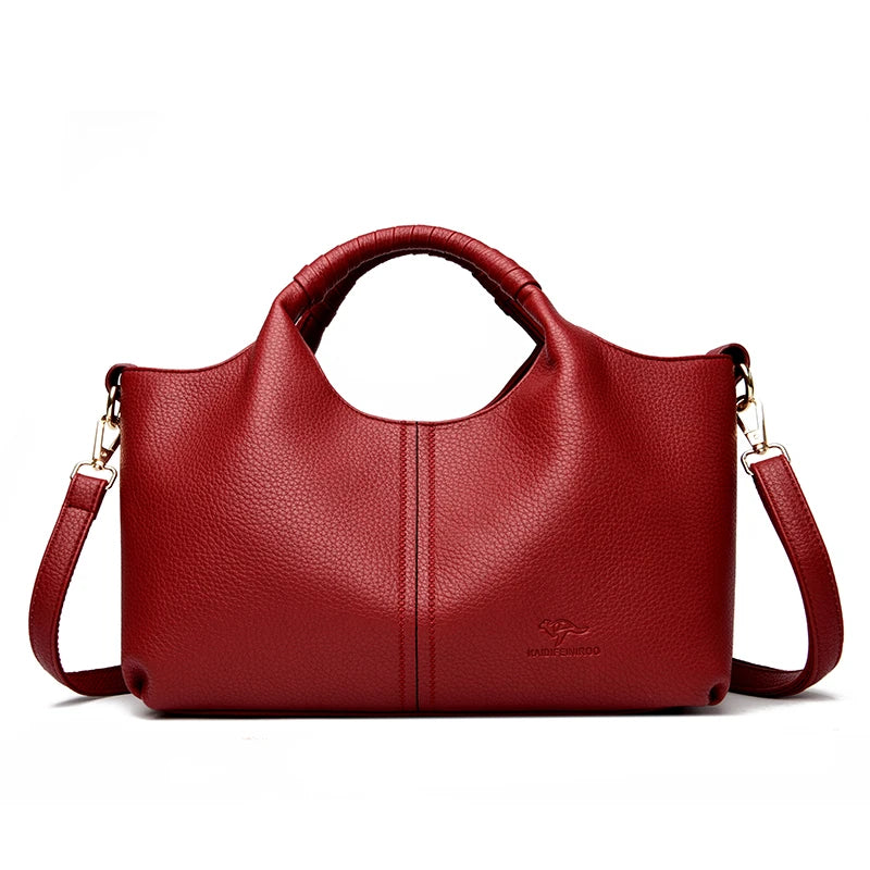 Red leather handbag with a shoulder strap on a white background