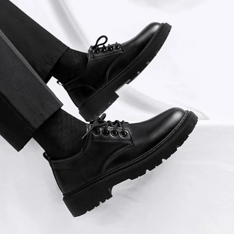 Black leather shoes worn with black pants on a white background