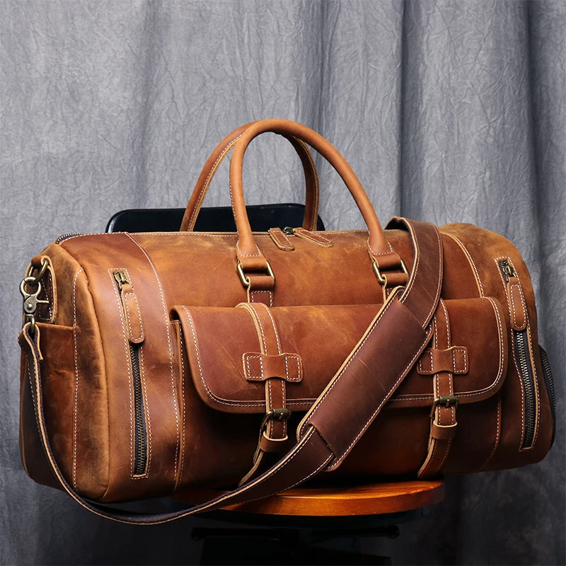 Brown leather duffel bag with 'MHK' monogram on a gray background